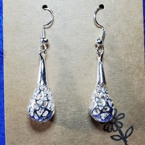 Intricate drooping eyelet tear drops. Glistening silver.